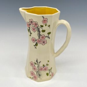 Small pink cherry blossom porcelain pitcher with yellow interior, front view