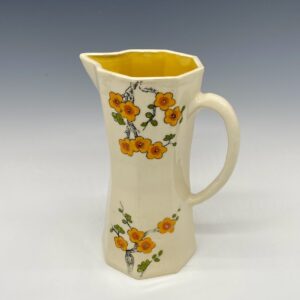 Small orange cherry blossom porcelain pitcher standing upright with floral design