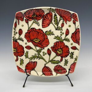 Front view of handmade square ceramic plate with embossed red poppy flowers, 9.5 x 9.5 inches.