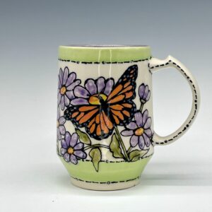 Hand-painted ceramic mug featuring an orange and black butterfly among purple flowers with green accents, view 0