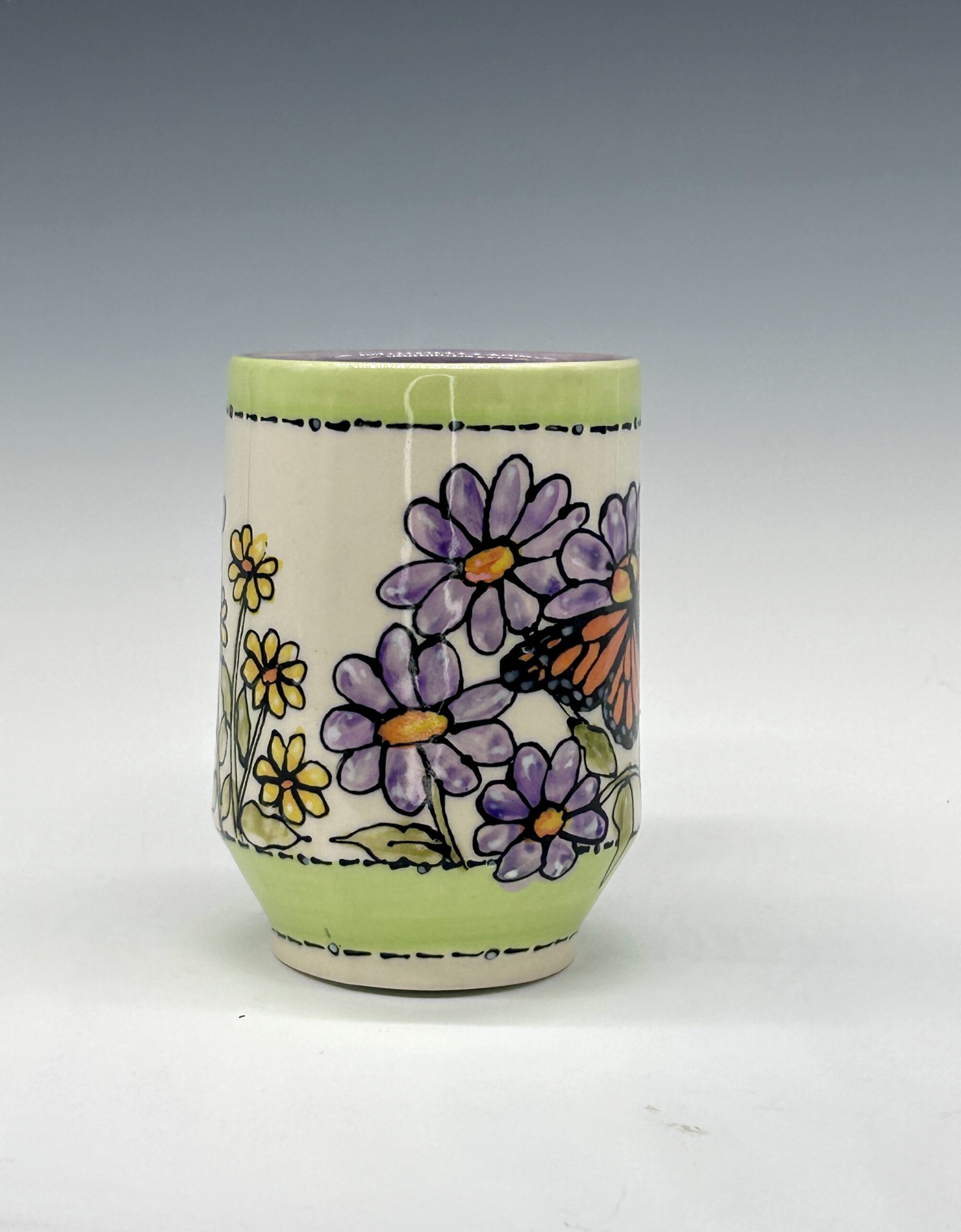 Hand-painted ceramic mug featuring an orange and black butterfly among purple flowers with green accents, view 1