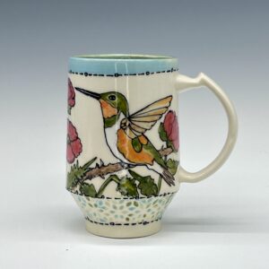 Hand-painted ceramic mug featuring a green and orange hummingbird among pink flowers, view 0