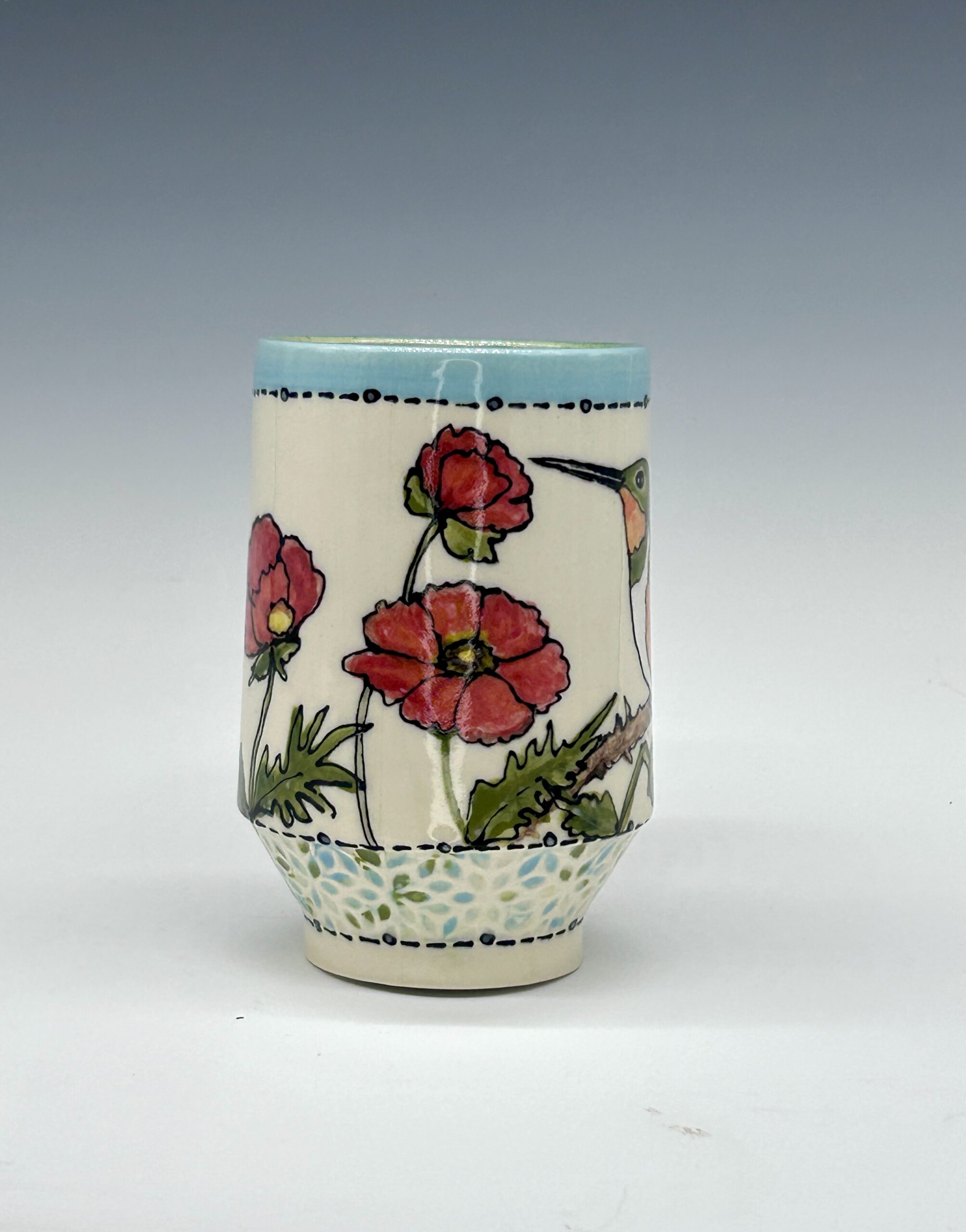 Hand-painted ceramic mug featuring a green and orange hummingbird among pink flowers, view 1